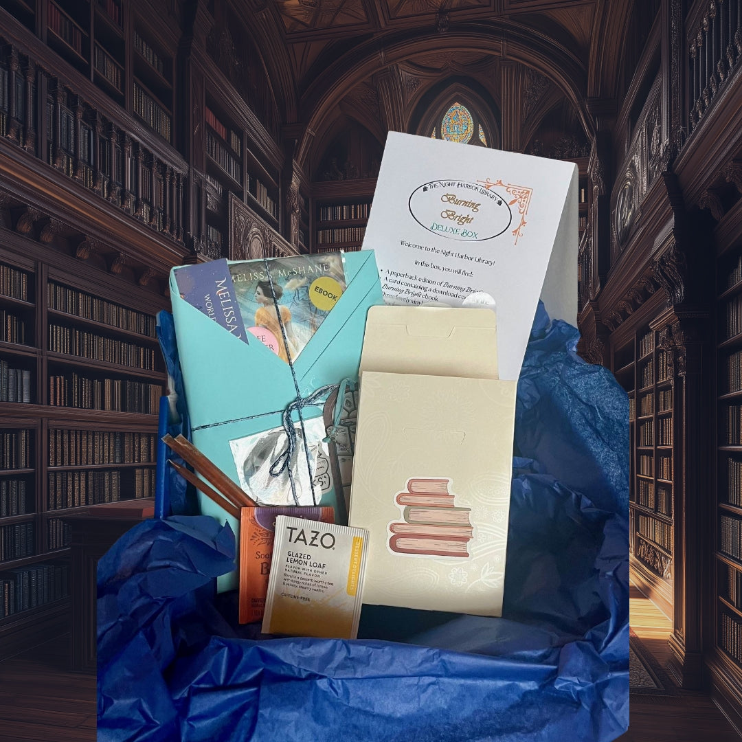 Packaged items including books and a Tazo box on blue tissue paper in a library setting